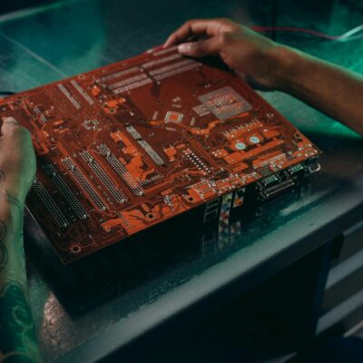 Close-up Photo of Motherboard being fixed by a Person