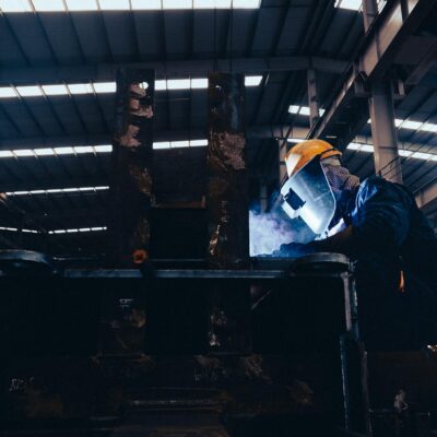 Man in a Protective Mask Doing Metalwork in a Workshop