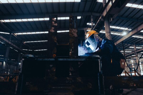 Man in a Protective Mask Doing Metalwork in a Workshop